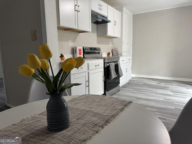 kitchen featuring white cabinets, electric range, and light hardwood / wood-style floors