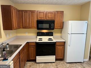 kitchen with range with electric cooktop, sink, and white fridge