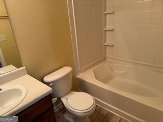 full bathroom featuring toilet, tiled shower / bath, and vanity