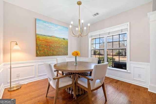 dining area with wood-type flooring and a chandelier