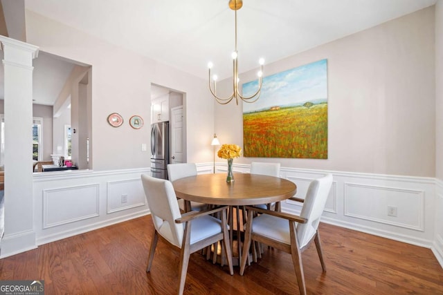 dining space with hardwood / wood-style flooring and a notable chandelier