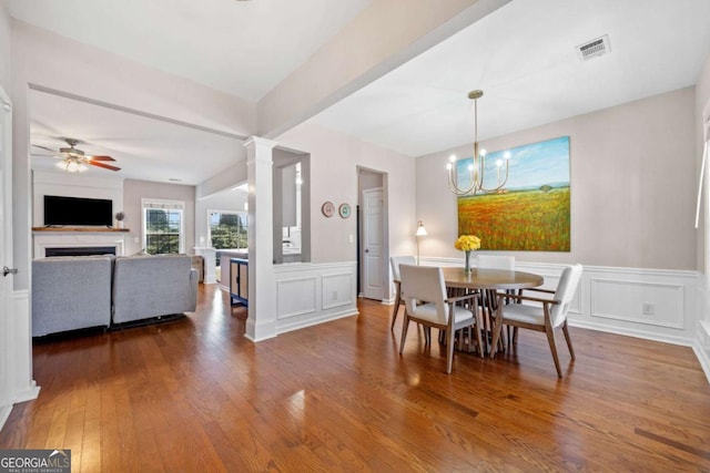 dining room with ceiling fan with notable chandelier and hardwood / wood-style flooring