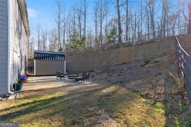 view of yard with an outdoor fire pit, a storage unit, and a patio area