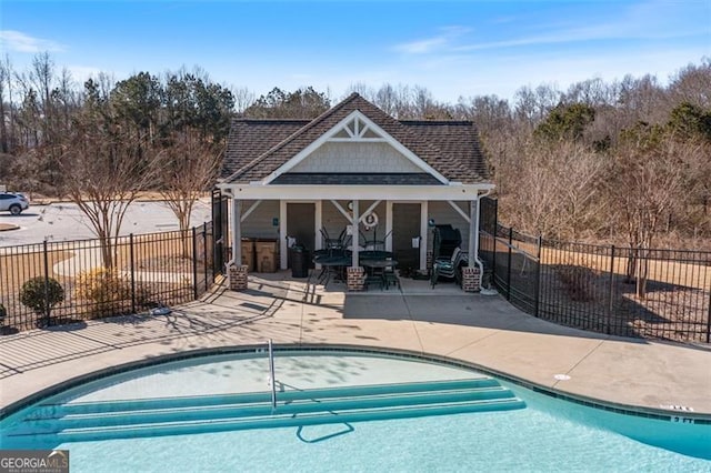 view of swimming pool featuring an outbuilding and a patio