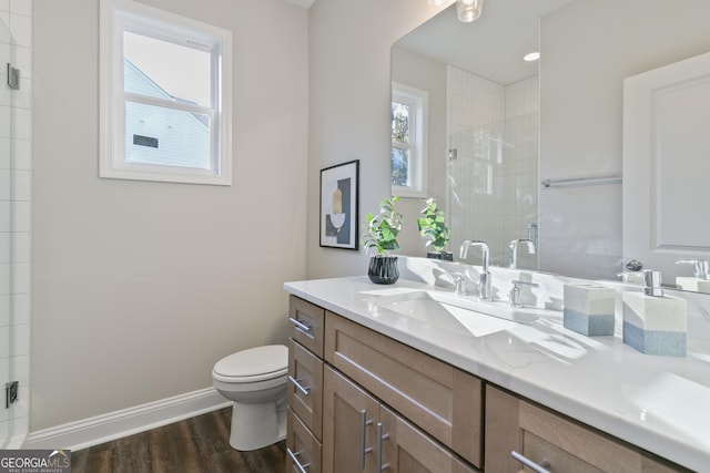 bathroom with a shower with shower door, vanity, toilet, and hardwood / wood-style flooring