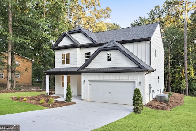 view of front of house featuring a front yard, cooling unit, covered porch, and a garage