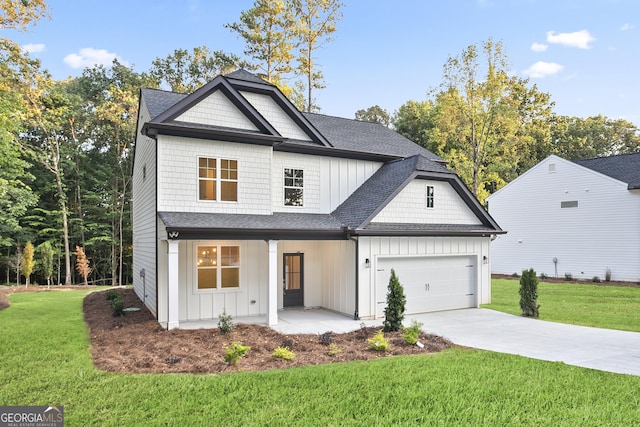 view of front of property featuring a front yard, covered porch, and a garage