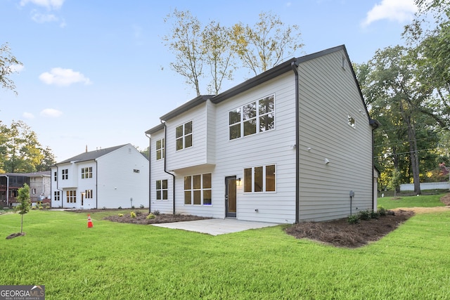 back of house with a lawn and a patio