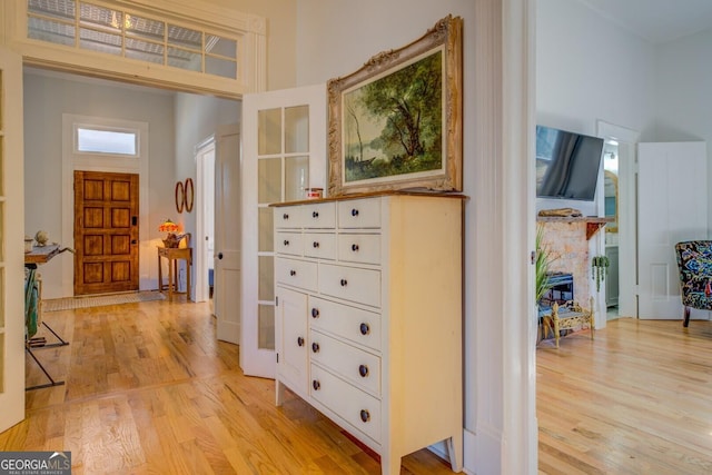 hallway with a high ceiling and light hardwood / wood-style flooring