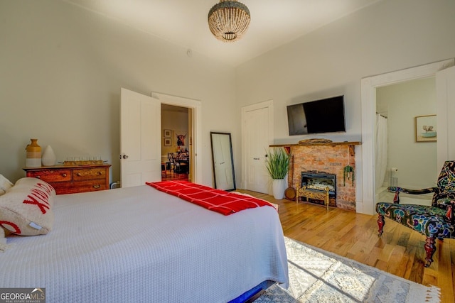 bedroom with a fireplace and wood-type flooring