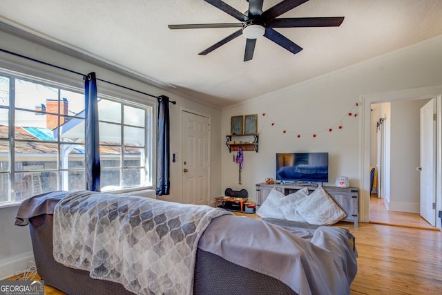 living room with ceiling fan, ornamental molding, lofted ceiling, and light hardwood / wood-style flooring