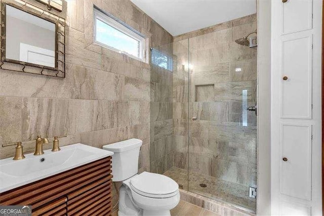 bathroom featuring tile walls, toilet, vanity, and an enclosed shower