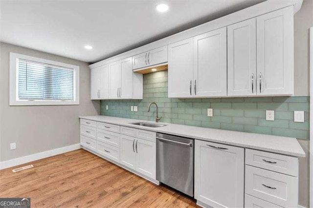 kitchen featuring dishwasher, light hardwood / wood-style floors, decorative backsplash, sink, and white cabinets