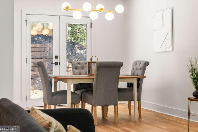 dining space with an inviting chandelier and light hardwood / wood-style flooring