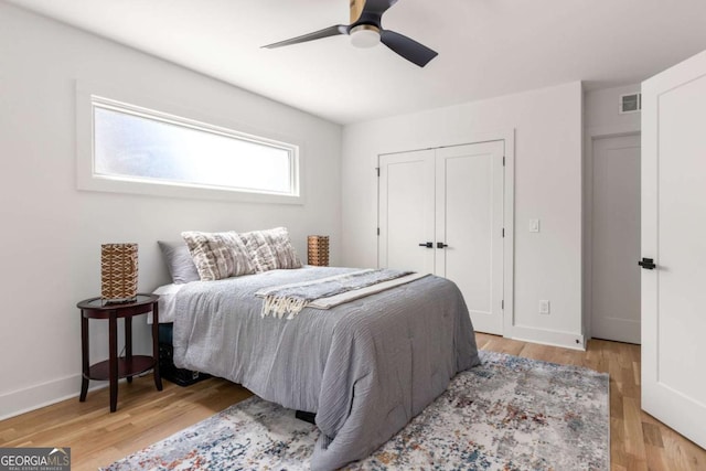 bedroom featuring ceiling fan, light wood-type flooring, and a closet