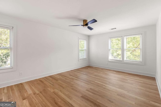 spare room with ceiling fan, a healthy amount of sunlight, and light wood-type flooring