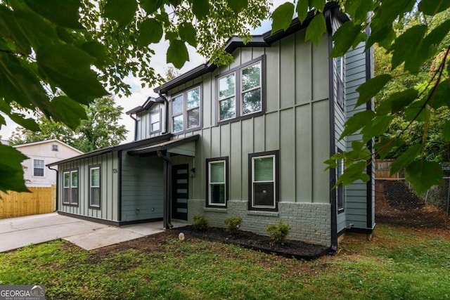 back of house featuring a patio area and a lawn