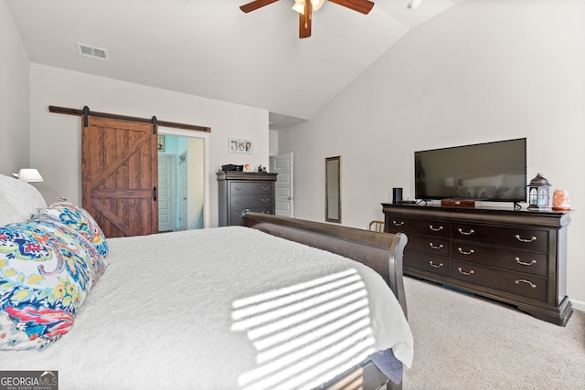 carpeted bedroom with ceiling fan, a barn door, and vaulted ceiling