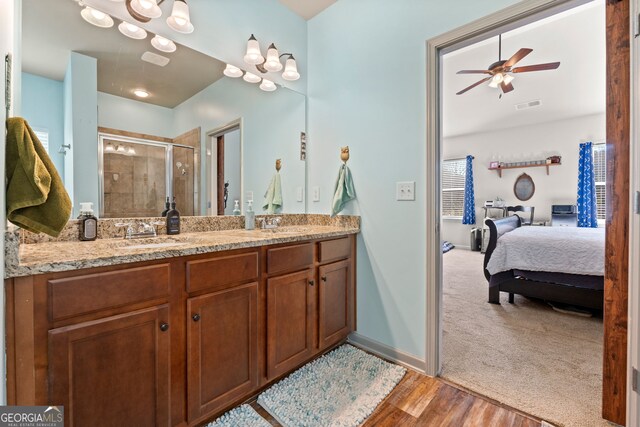 bathroom featuring vanity, ceiling fan, wood-type flooring, and a shower with door