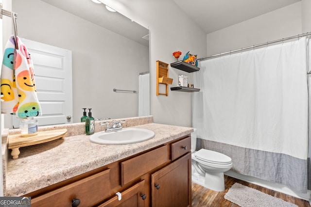 bathroom featuring wood-type flooring, toilet, and vanity