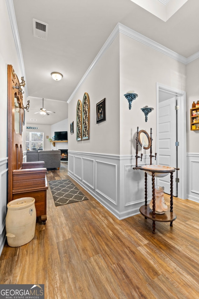 hallway with hardwood / wood-style floors and ornamental molding