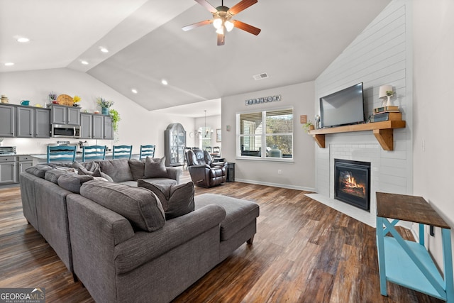 living room featuring vaulted ceiling, dark wood-type flooring, and ceiling fan with notable chandelier