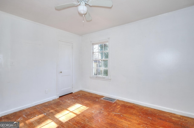 empty room featuring ceiling fan, crown molding, and hardwood / wood-style flooring