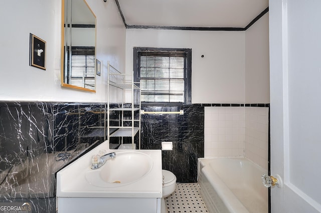 bathroom featuring toilet, a healthy amount of sunlight, tile walls, and a washtub