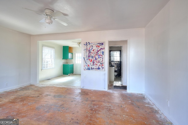 empty room featuring ceiling fan and crown molding