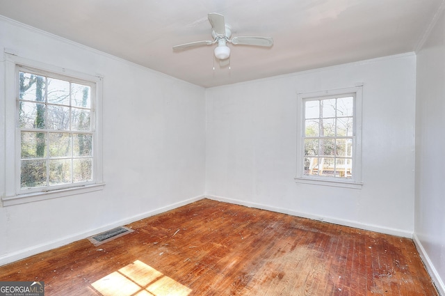 spare room with ceiling fan, plenty of natural light, wood-type flooring, and ornamental molding