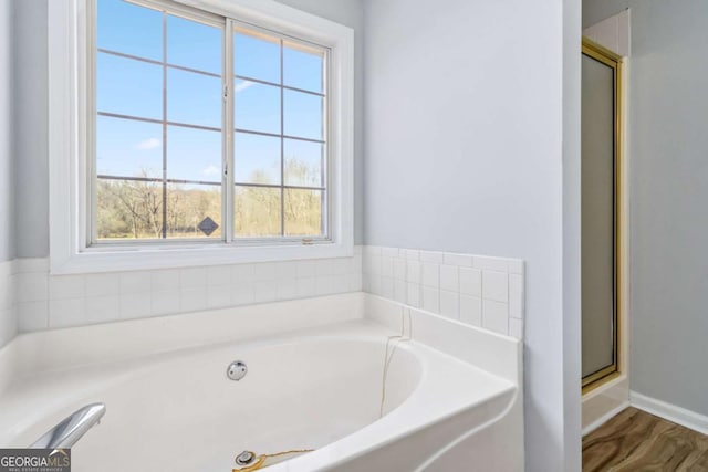 bathroom with plenty of natural light, hardwood / wood-style floors, and shower with separate bathtub