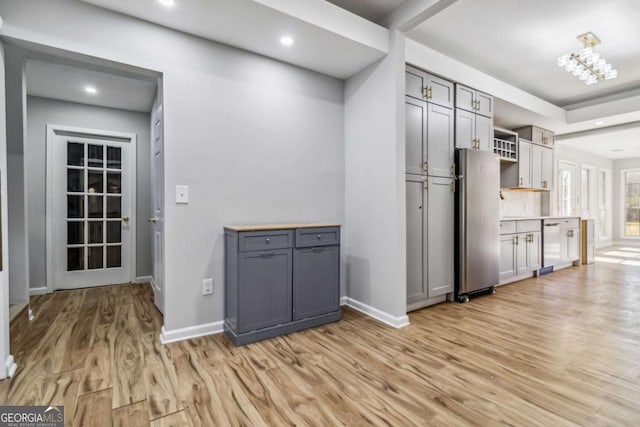 kitchen with gray cabinets, stainless steel appliances, and light hardwood / wood-style flooring