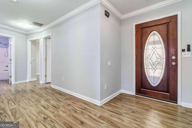 entryway with ornamental molding and light hardwood / wood-style flooring