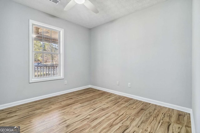 unfurnished room featuring a textured ceiling, ceiling fan, and light hardwood / wood-style flooring