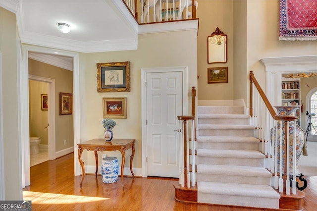 stairway featuring crown molding and hardwood / wood-style flooring