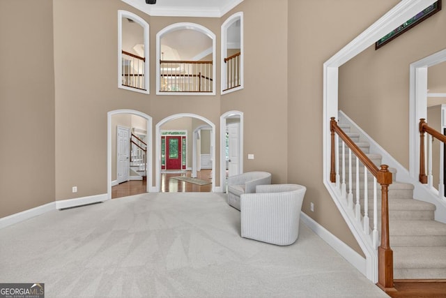 4225 Dunham Park, Flowery Branch, GA 30542 - unfurnished room featuring arched walkways, stairway, carpet flooring, ornamental molding, and a high ceiling