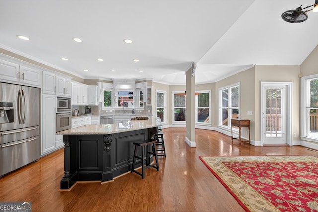 4225 Dunham Park, Flowery Branch, GA 30542 - kitchen with stainless steel appliances, white cabinets, healthy amount of natural light, light stone counters, and crown molding