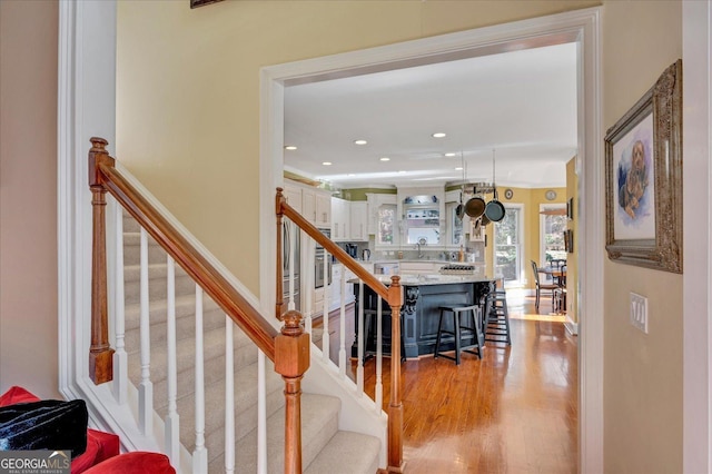 stairway with sink and hardwood / wood-style floors