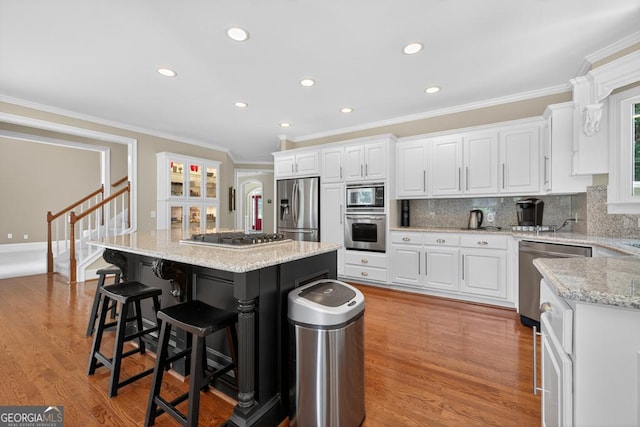 4225 Dunham Park, Flowery Branch, GA 30542 - kitchen with appliances with stainless steel finishes, white cabinets, a kitchen island, crown molding, and recessed lighting