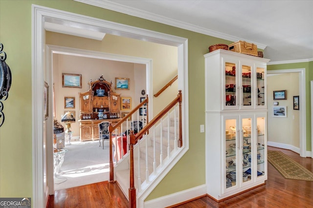 stairway featuring hardwood / wood-style flooring and ornamental molding