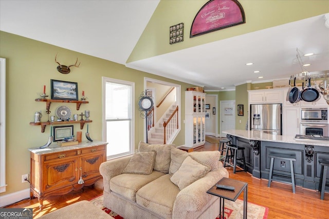 living room with vaulted ceiling and light hardwood / wood-style floors