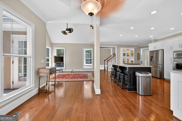 4225 Dunham Park, Flowery Branch, GA 30542 - kitchen featuring stainless steel appliances, wood finished floors, a breakfast bar, white cabinets, and crown molding