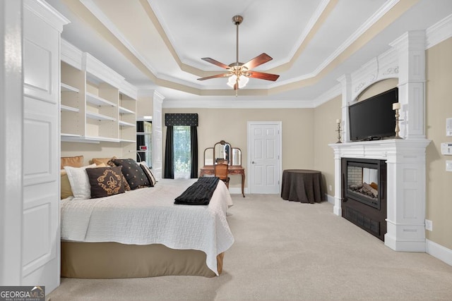 4225 Dunham Park, Flowery Branch, GA 30542 - bedroom featuring a raised ceiling, a glass covered fireplace, carpet flooring, ornamental molding, and a ceiling fan