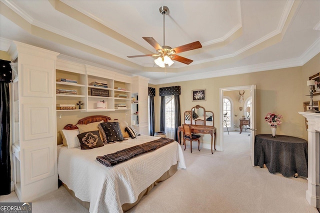 bedroom with ceiling fan, ornamental molding, light colored carpet, and a tray ceiling