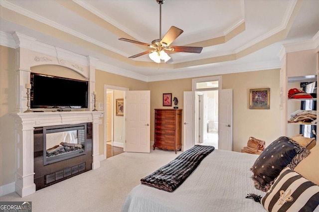 carpeted bedroom featuring ceiling fan, a multi sided fireplace, ornamental molding, and a raised ceiling