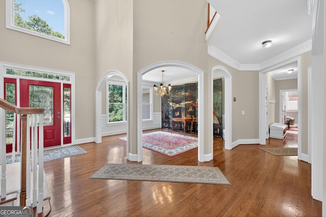 4225 Dunham Park, Flowery Branch, GA 30542 - foyer entrance with a chandelier, ornamental molding, arched walkways, wood finished floors, and a high ceiling