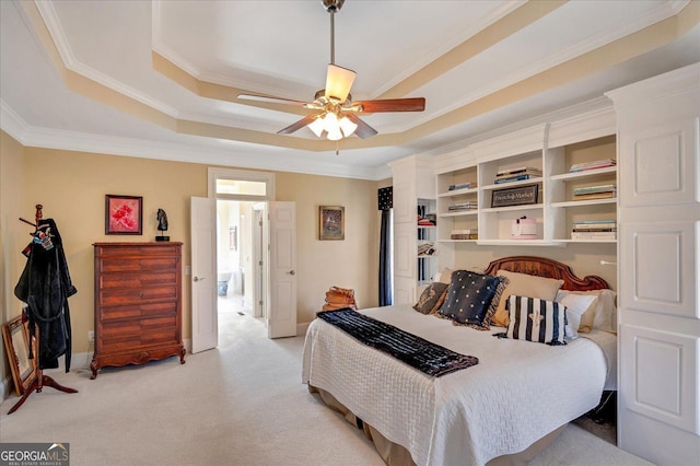 carpeted bedroom featuring ceiling fan, ornamental molding, and a raised ceiling