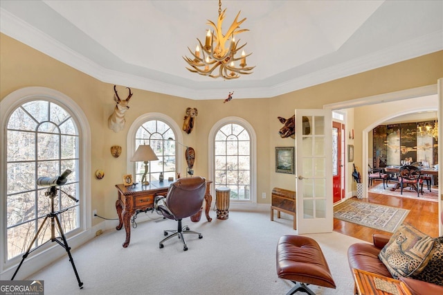 office with french doors, a tray ceiling, ornamental molding, and a chandelier