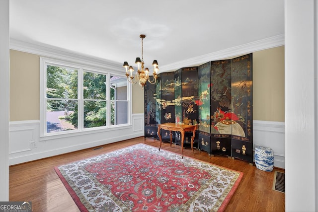 4225 Dunham Park, Flowery Branch, GA 30542 - dining space with a chandelier, crown molding, wood finished floors, and wainscoting