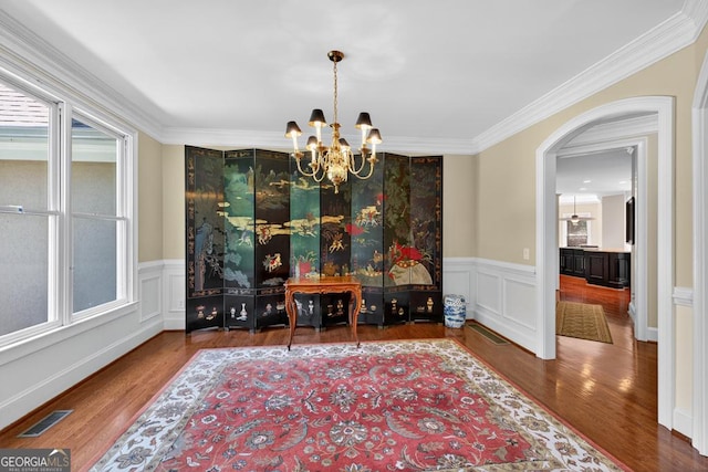 4225 Dunham Park, Flowery Branch, GA 30542 - dining area featuring a chandelier, wood finished floors, ornamental molding, a wainscoted wall, and arched walkways